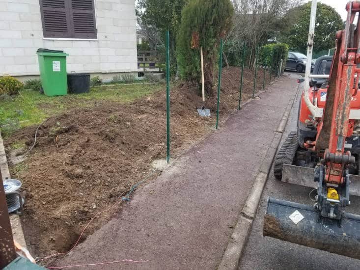 Mini-pelle ouvrant une tranchée le long d’un trottoir