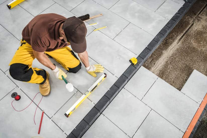 Gros plan sur M GAYET entrain d'installer des pavés pour créer une terrasse dans les Yvelines